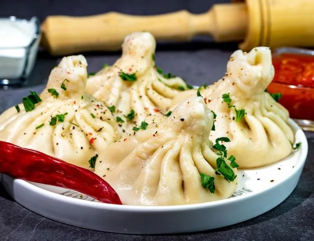 Хинкали - Хинкали рецепт. 500 г мясного фарша, 1 луковица, 1 зубчик чеснока, 500 г муки, 730 миллилитров воды, 1 чайная ложка смеси перцев, 0.33 г перца чили, 50 г зелени кинзы, соль по вкусу. Хинкали - Рецепт
