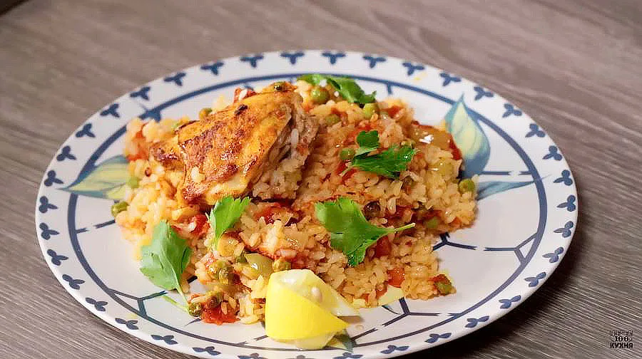 Курица с рисом по-испански - Рецепт курицы с рисом по-испански: куриные бедра кладем на обильно смазанную растительным маслом сковороду. Через несколько минут кладем нарезанный слайсами чеснок. Жарить курицу до готовности не нужно, важна только золотистая корочка. Добавляем соль, перец и паприку. Курица с рисом по-испански - Рецепт
